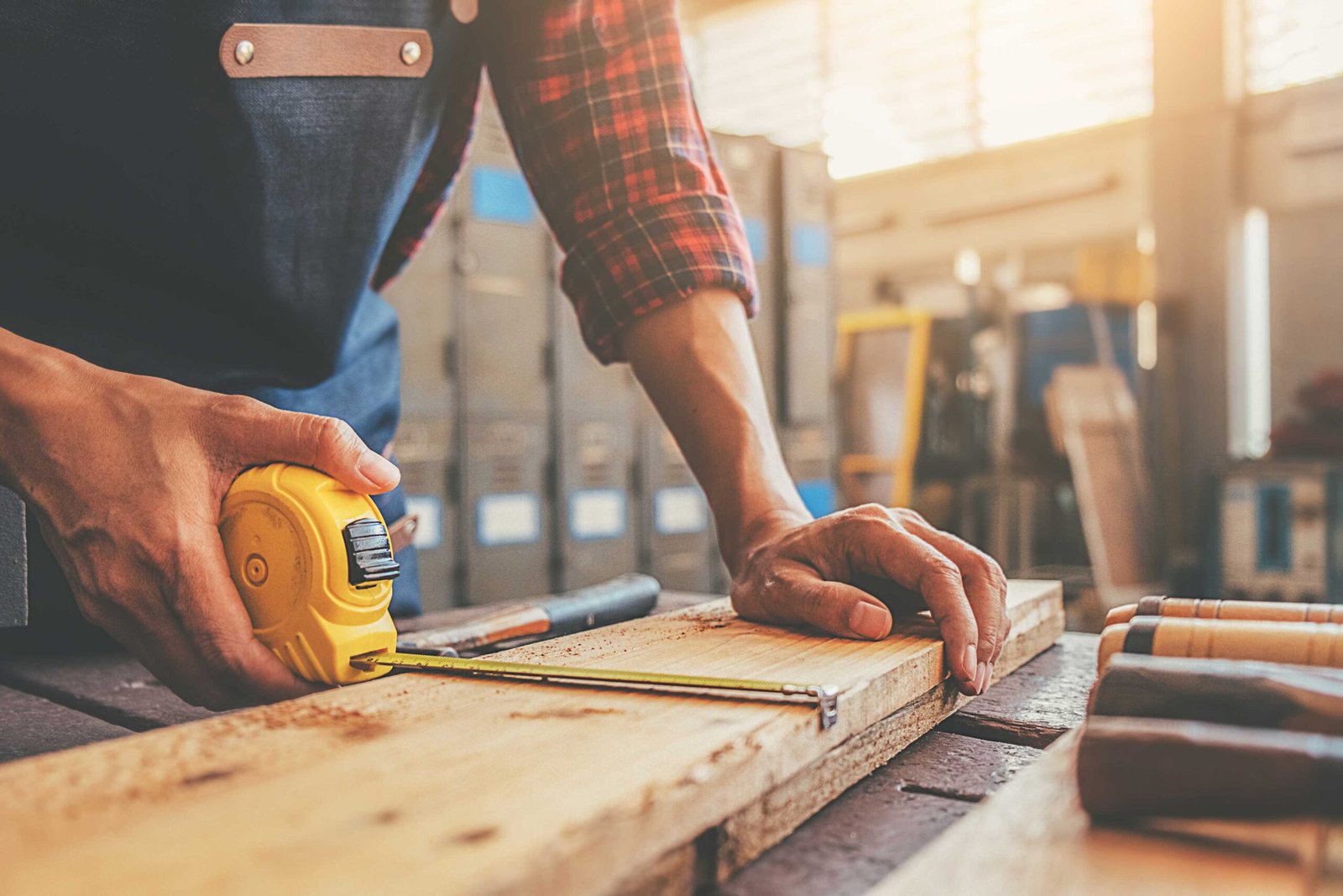 carpenter working with equipment on wooden table in carpentry sh